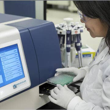 Científico trabajando en un lector de microplacas